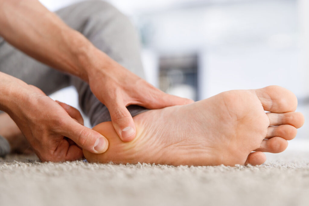 back of the heel pain, man massaging his heel